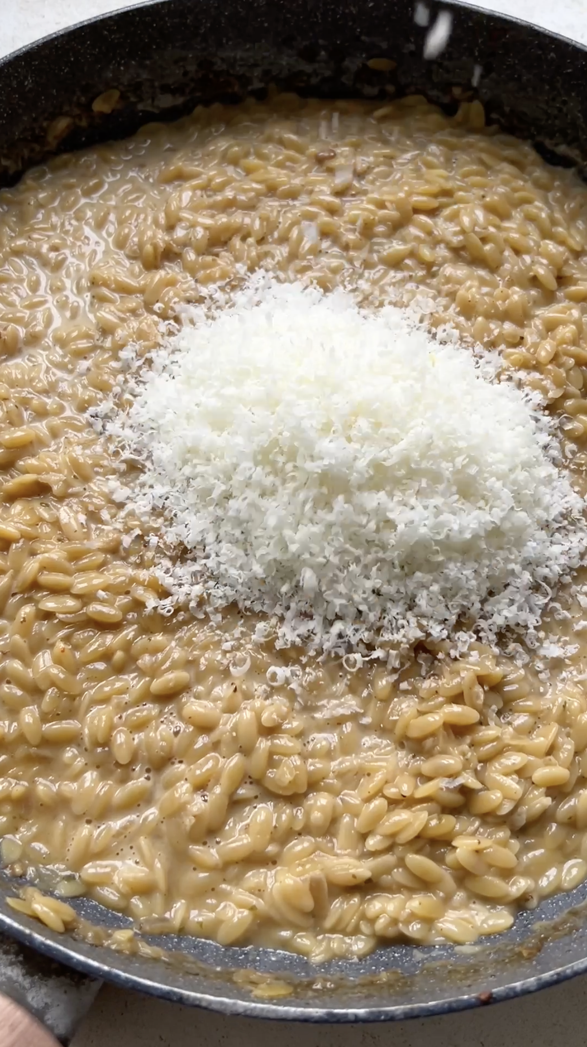 Freshly grated Parmesan cheese added to pasta.