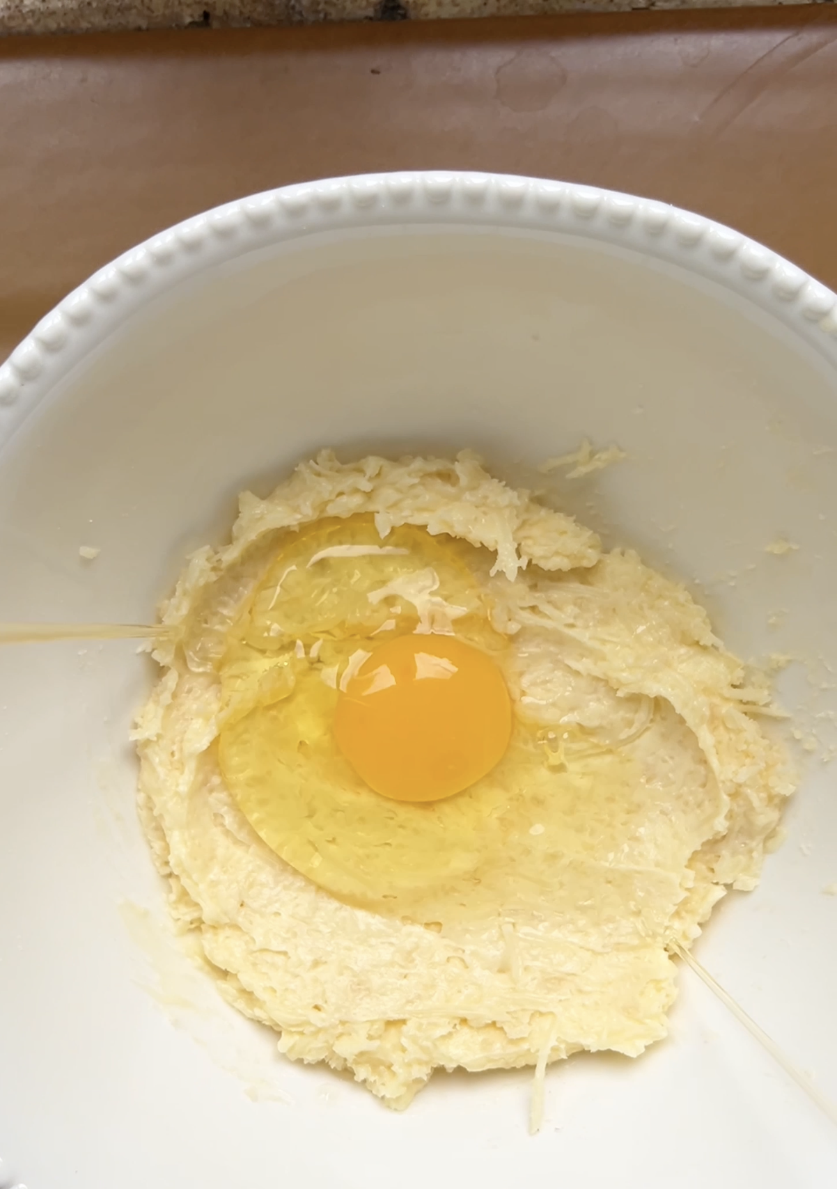 Egg added to the mixture of butter and grated cheeses.