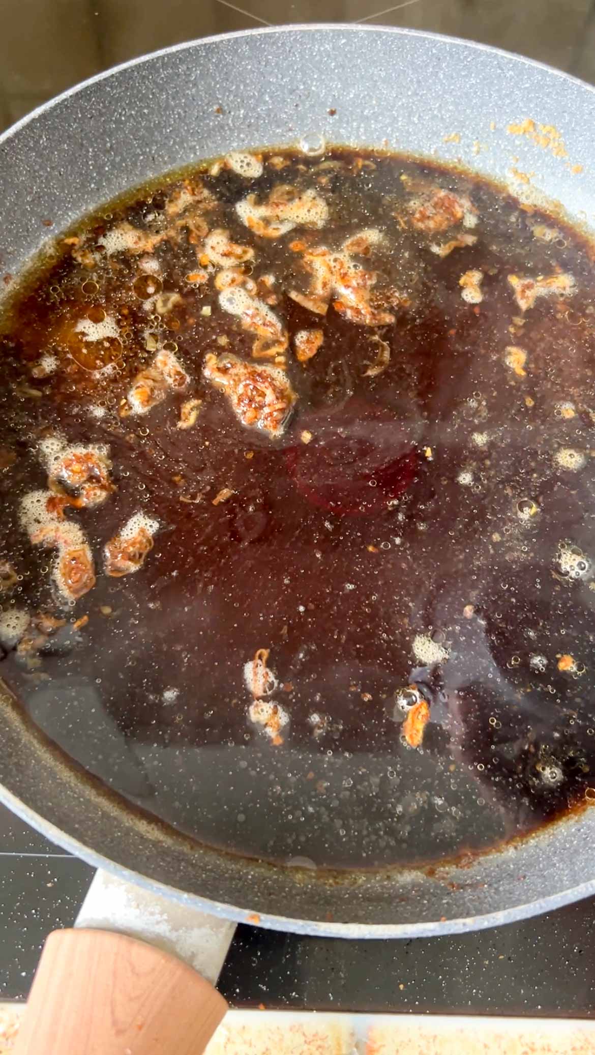 Soy sauce added to the frying pan of minced shallot and Dashi stock.