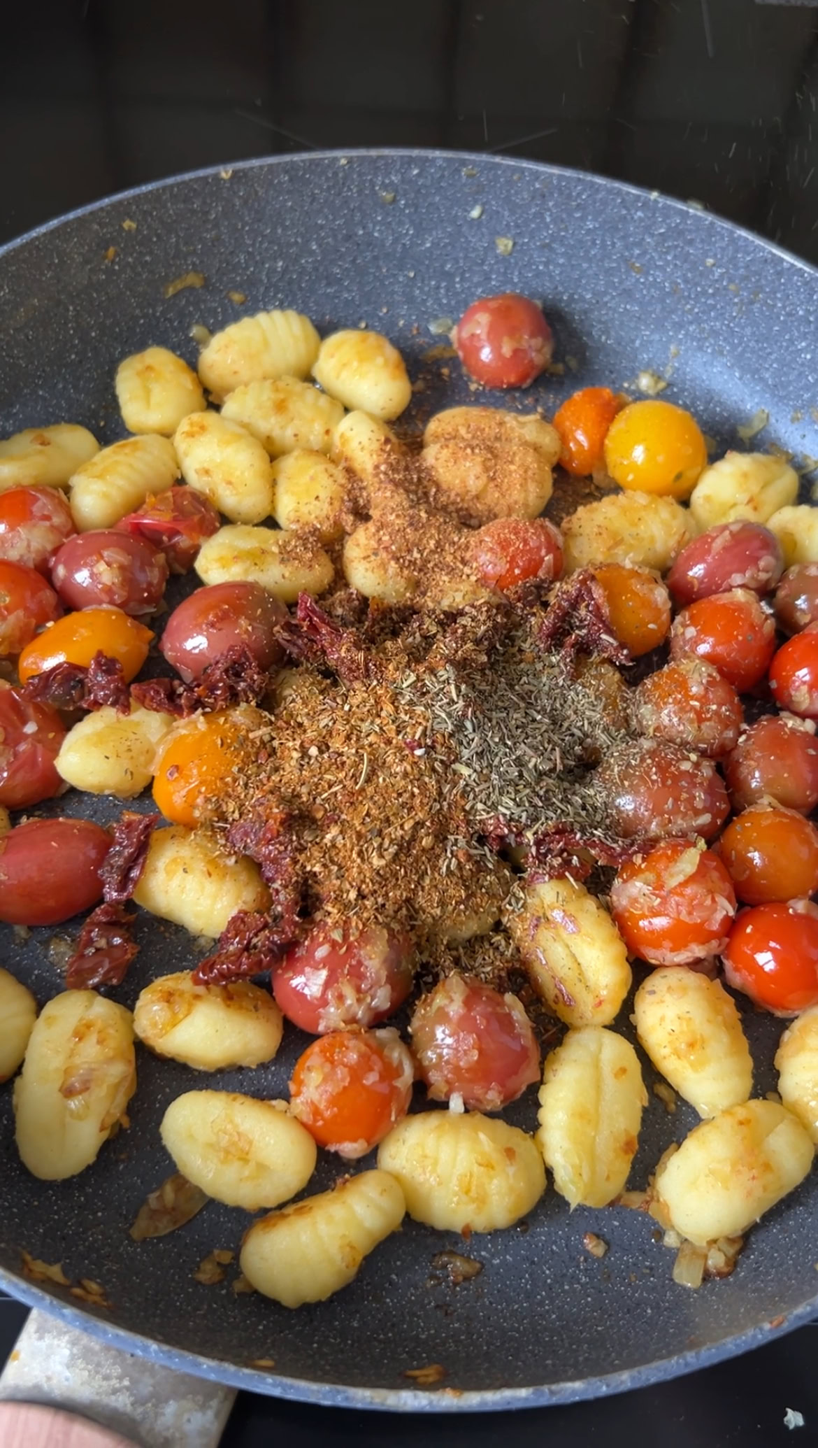 Espelette pepper, oregano and Italian seasoning added to the pan of gnocchi.