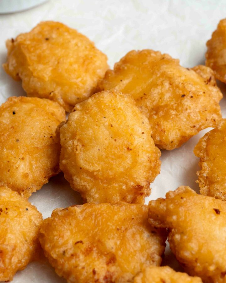 Homemade chicken nuggets on a sheet of parchment paper.