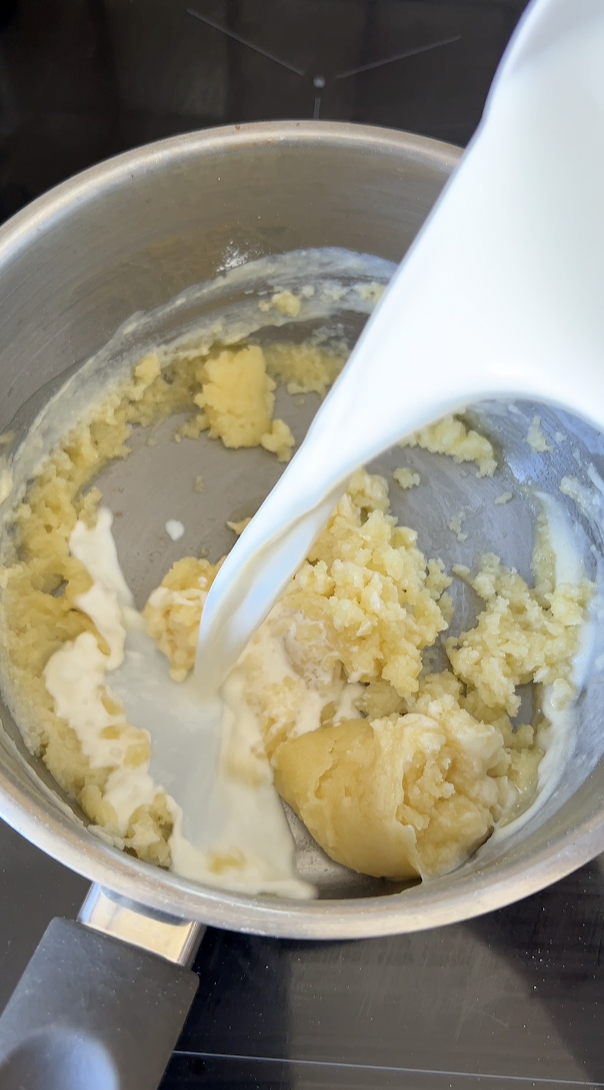 Roux dans une casserole avec du lait versé.