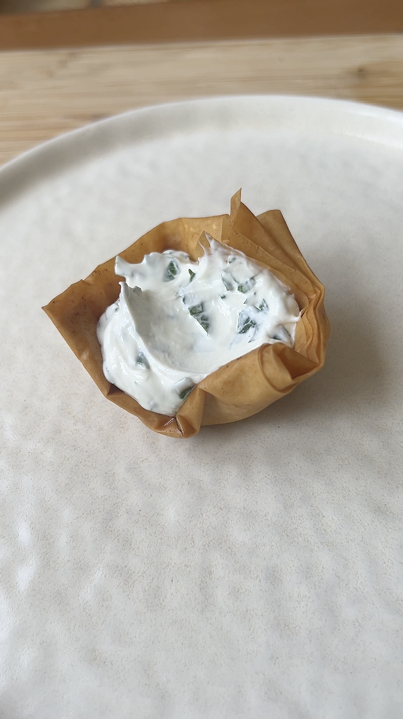 Fromage frais déposé dans une petite cup cuite et dorée.