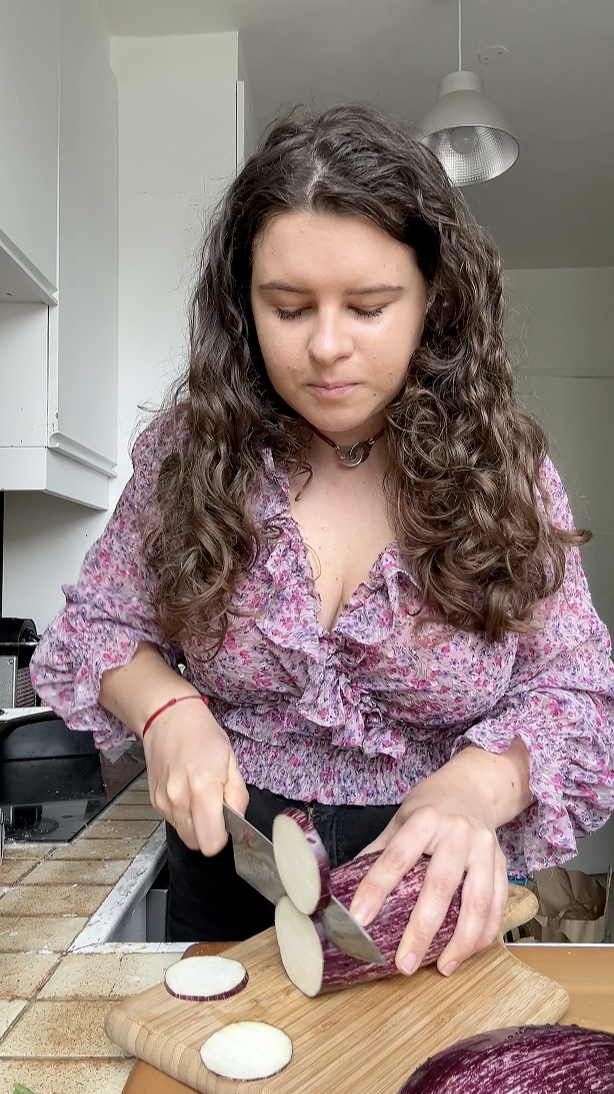 Marie cutting slices of eggplant.