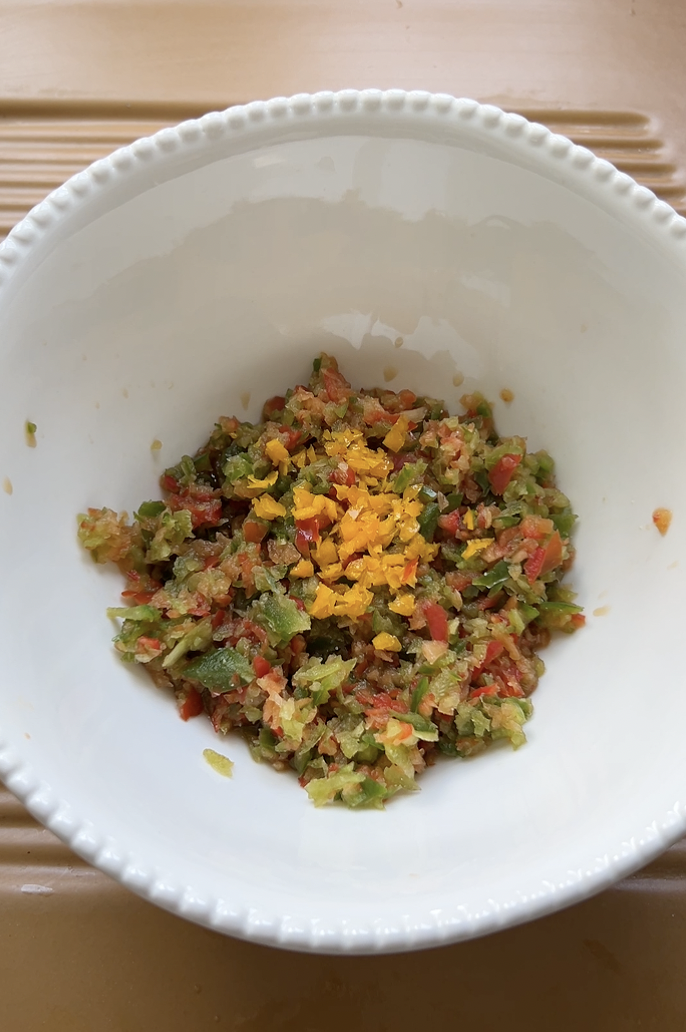 Chopped peppers and Habanero pepper in a large white bowl.