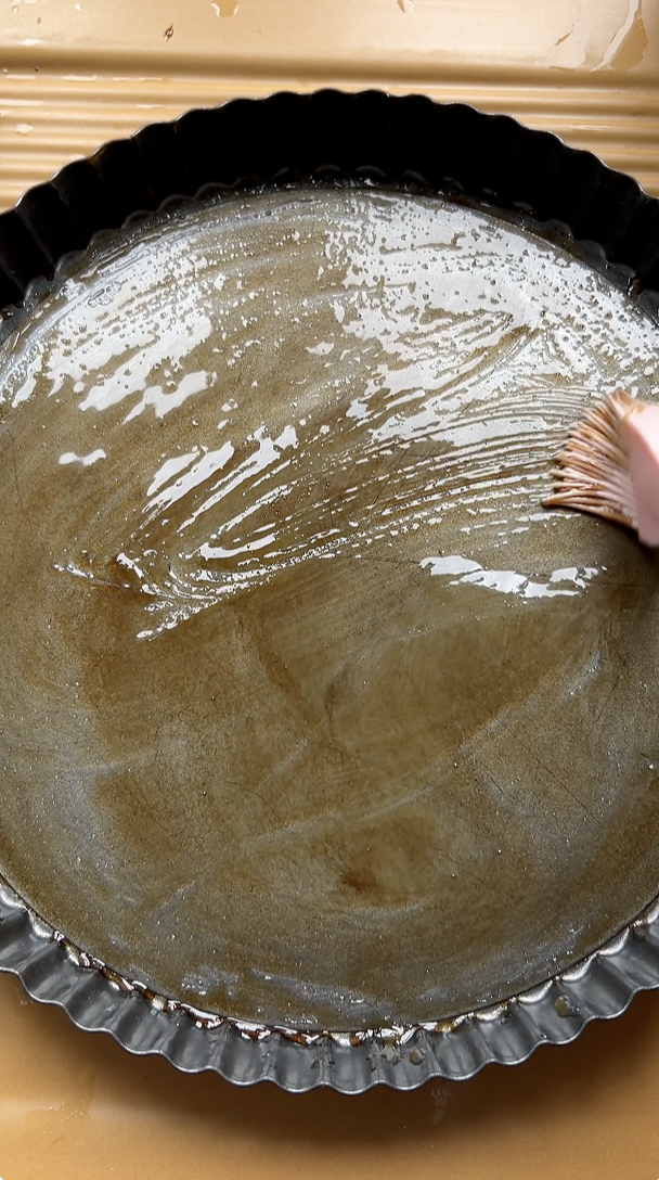 Removable-bottom tart mould with olive oil, vinegar and honey spread.