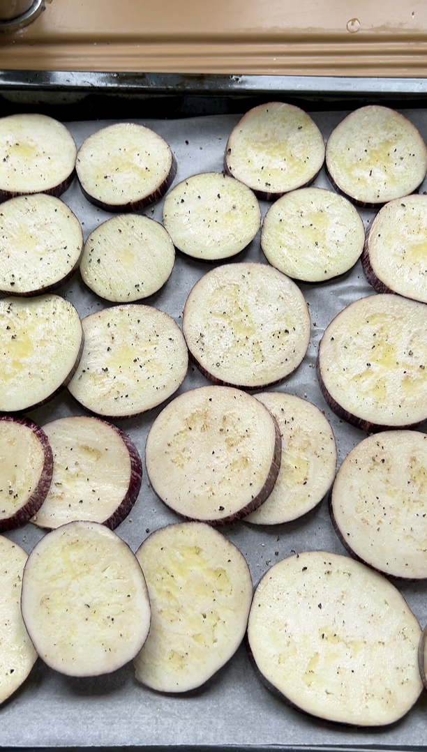 Slices of eggplant with oil, salt and pepper, before baking.