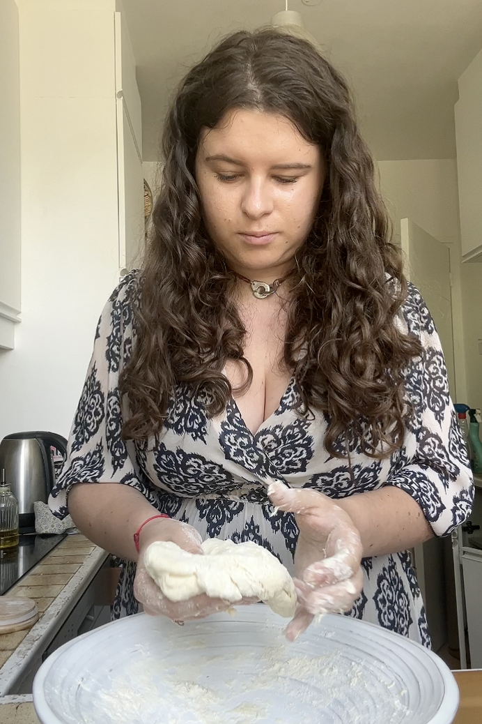 Marie qui pétrit la pâte pour former une boule.