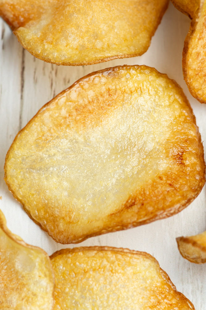 Homemade potato chips on parchment paper.