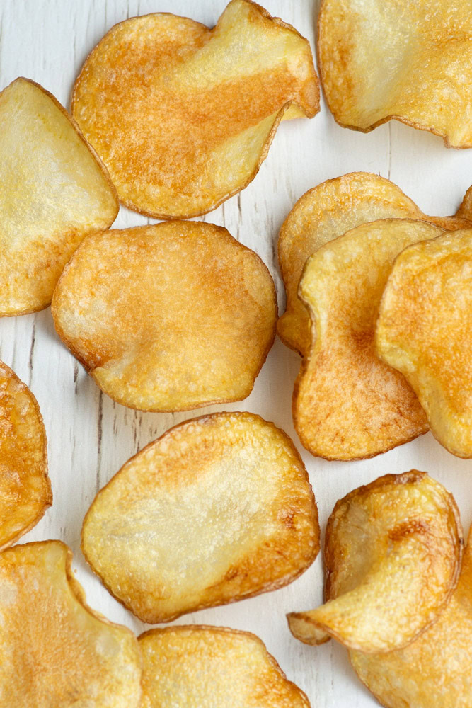 Homemade potato chips on parchment paper.