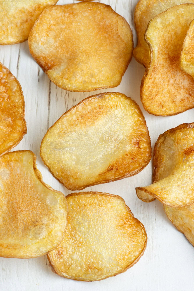 Homemade potato chips on parchment paper.