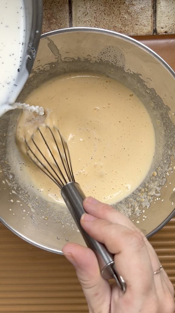 Casserole de lait versée petit à petit sur le mélange de jaunes d'oeuf et de sucre battu.