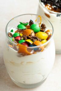 Homemade McFlurry in a glass, with caramel topping and crushed M&Ms on top.