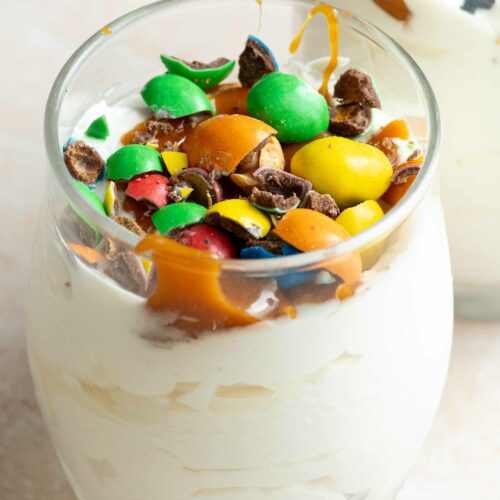 Homemade McFlurry in a glass, with caramel topping and crushed M&Ms on top.