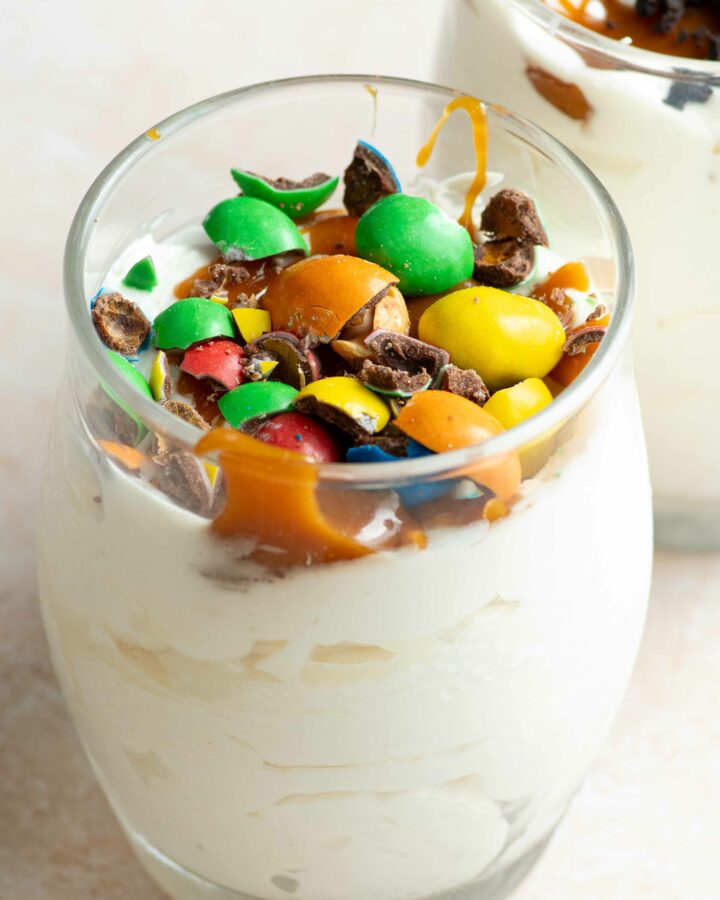 Homemade McFlurry in a glass, with caramel topping and crushed M&Ms on top.