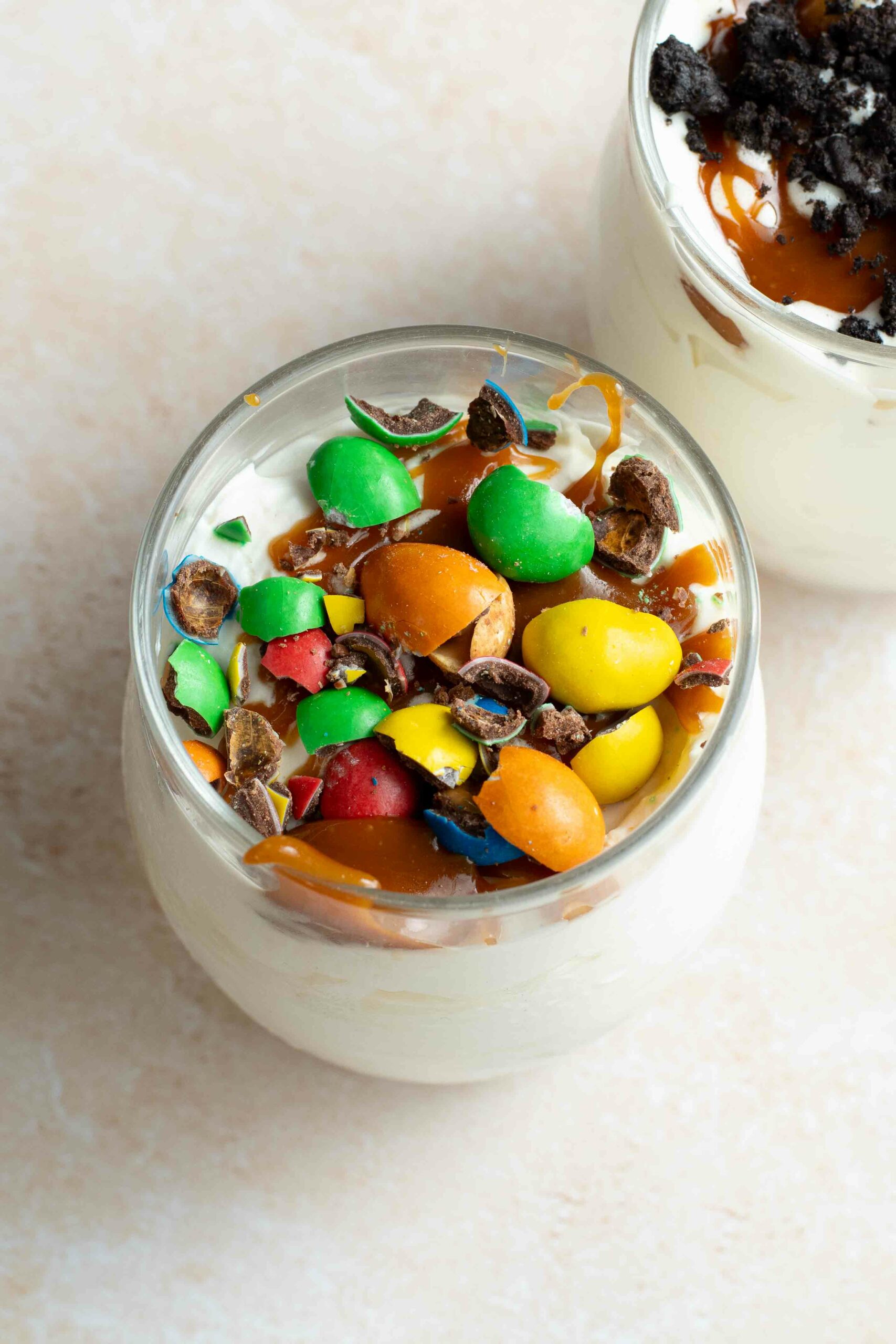 Homemade McFlurry in a glass, with caramel topping and crushed M&Ms on top.