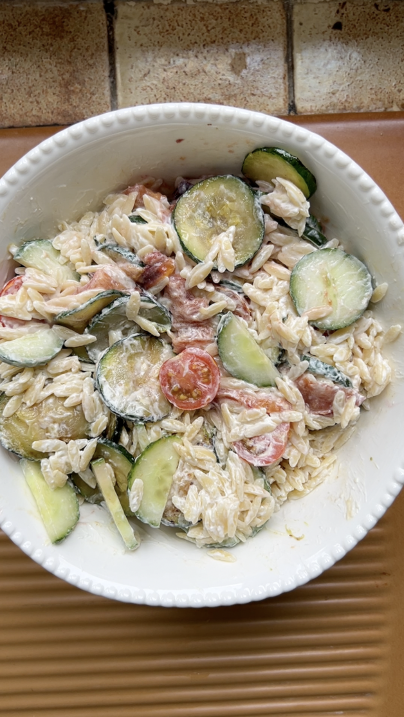 Mix the vegetables, pasta and cream cheese in the large white salad bowl.