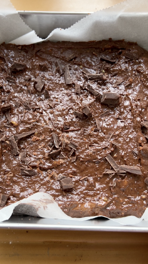 Chocolate mixture poured into the mould, with pieces of chocolate, before baking.