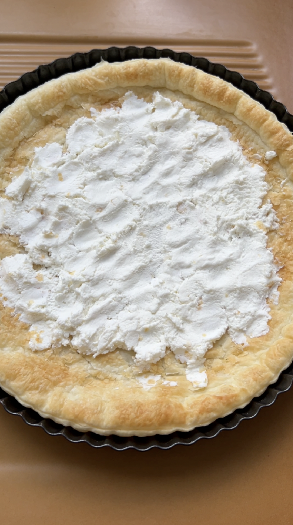 Pâte feuilletée après sa cuisson, recouverte de fromage de chèvre.