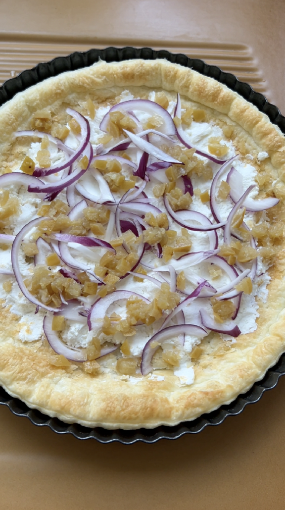 Slices of red onion added to the puff pastry.