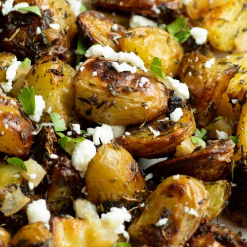 Potatoes with preserved lemon, feta cheese and parsley on a plate.