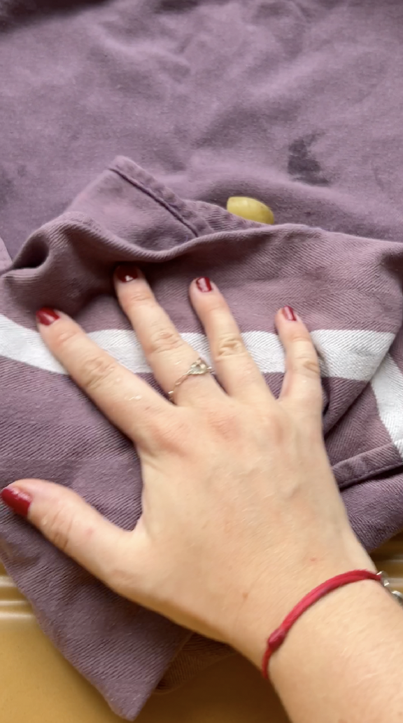 Hand drying the cut potatoes with the purple kitchen towel.