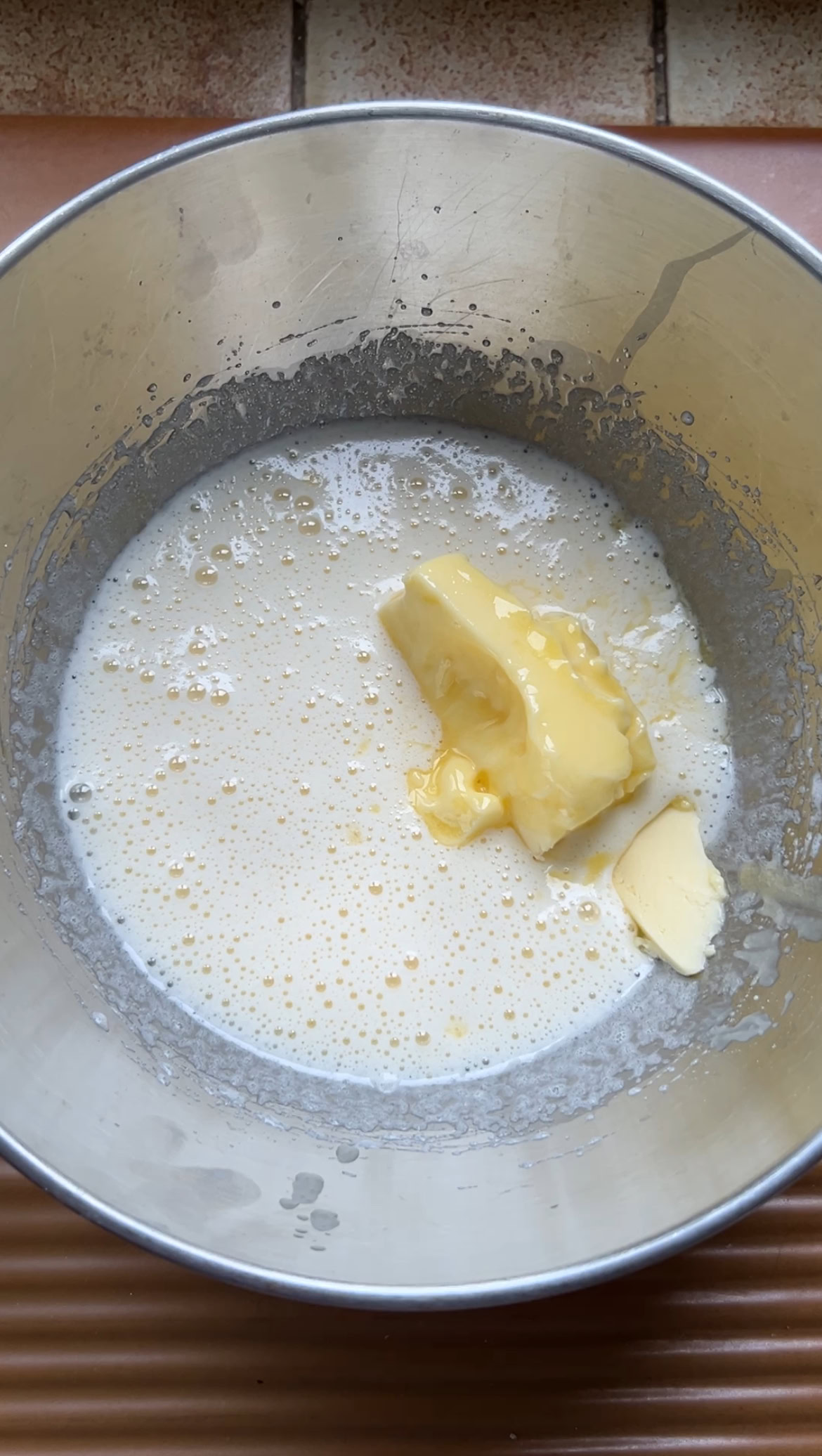 Soft butter added to the aluminium bowl of sugar and egg.