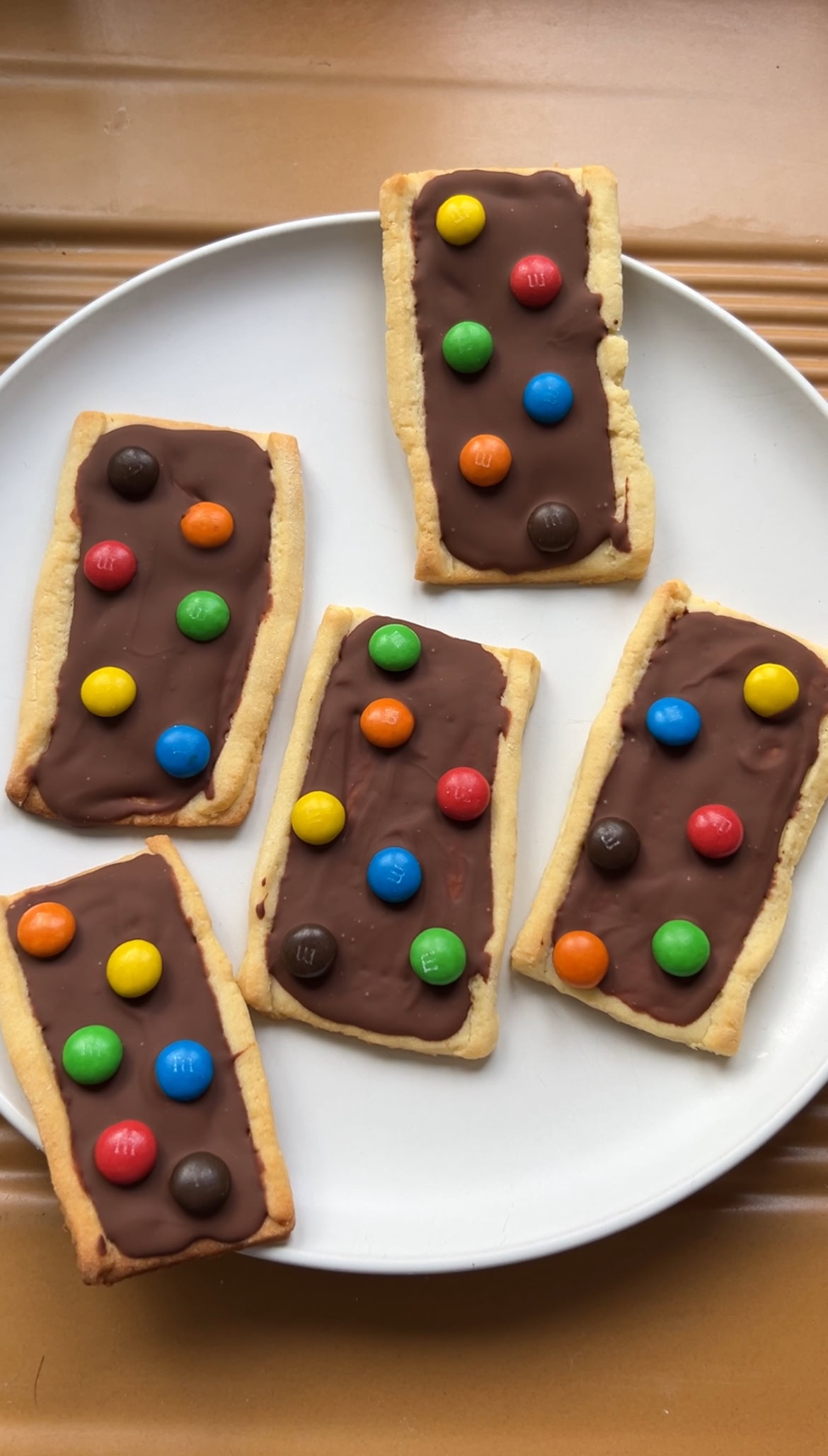 Baked M&Ms shortbread biscuits topped with set chocolate and mini M&Ms.