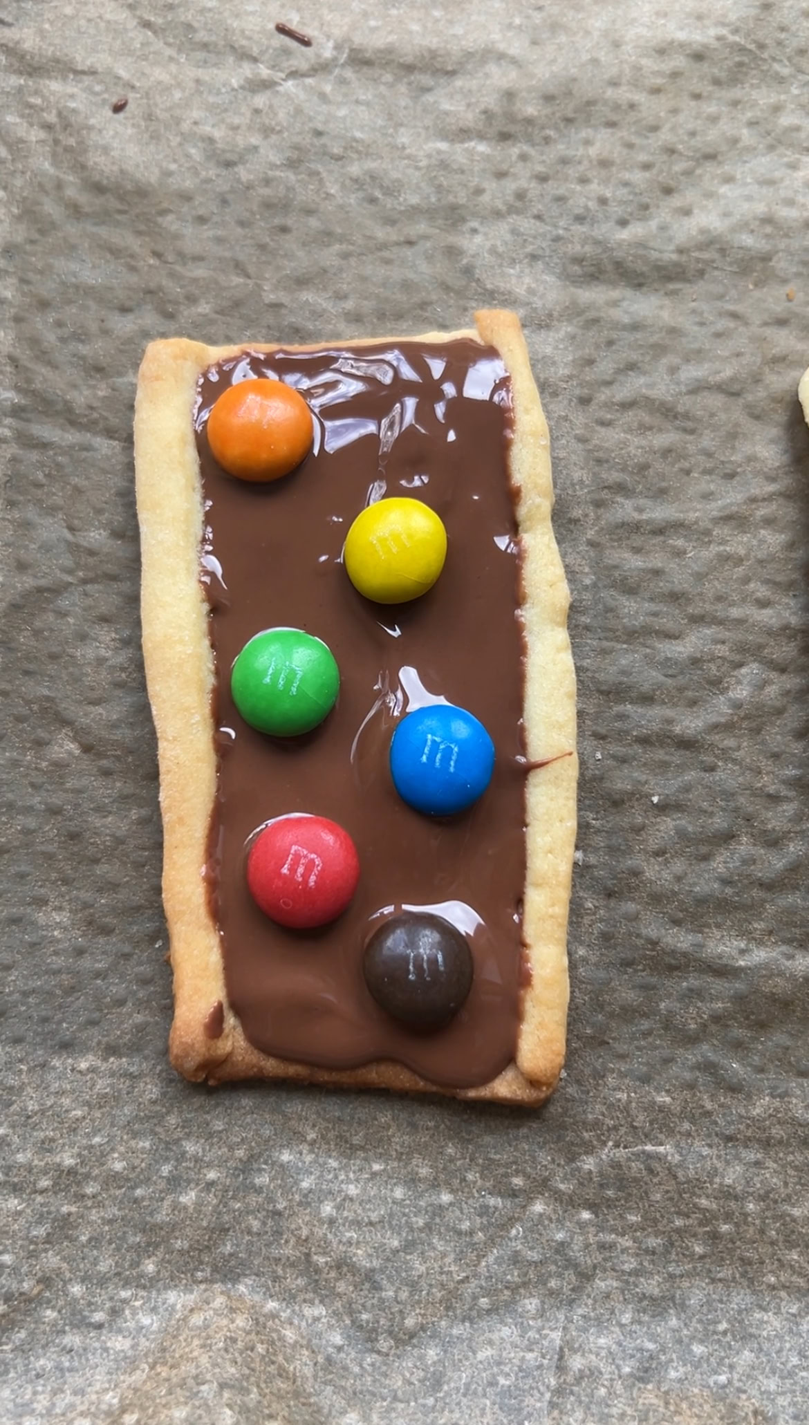 Baked M&Ms shortbread biscuits topped with melted chocolate and mini M&Ms.