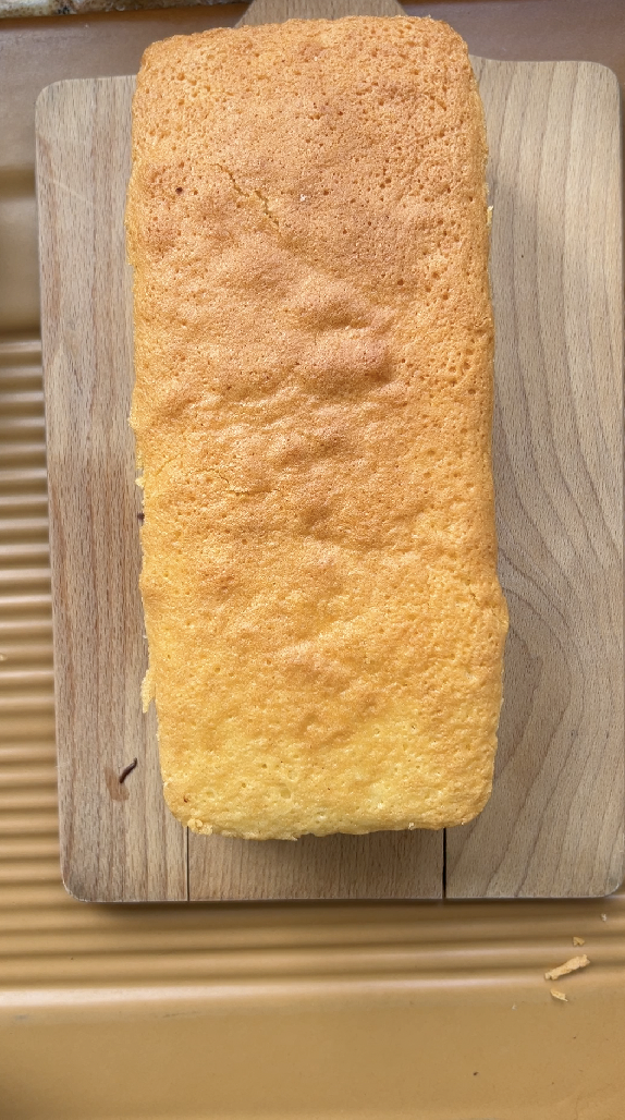 The last plain sponge cake is placed on top of the first two sponge cakes.