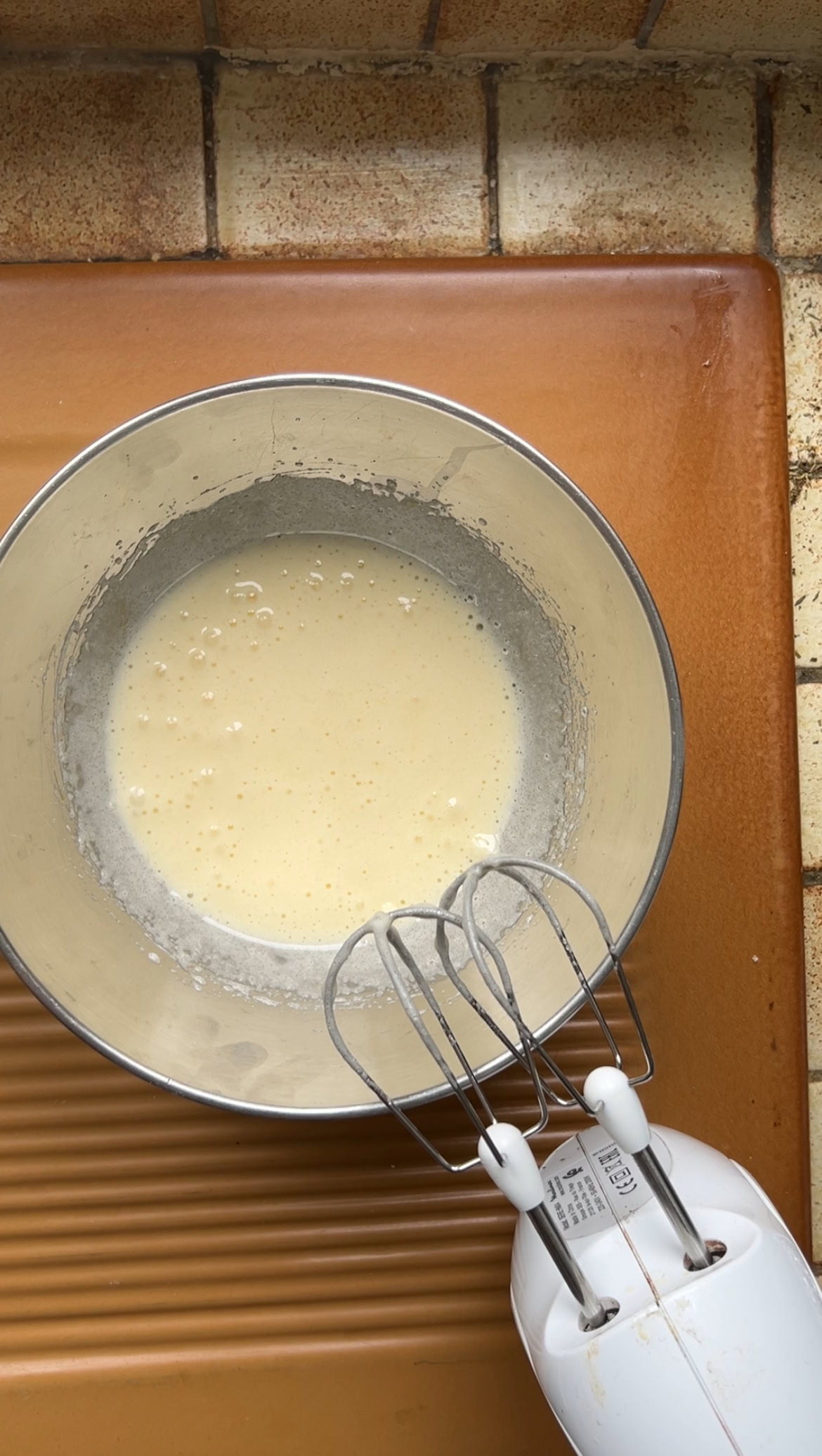 Oeuf et sucre mélangés dans le bol en inox.