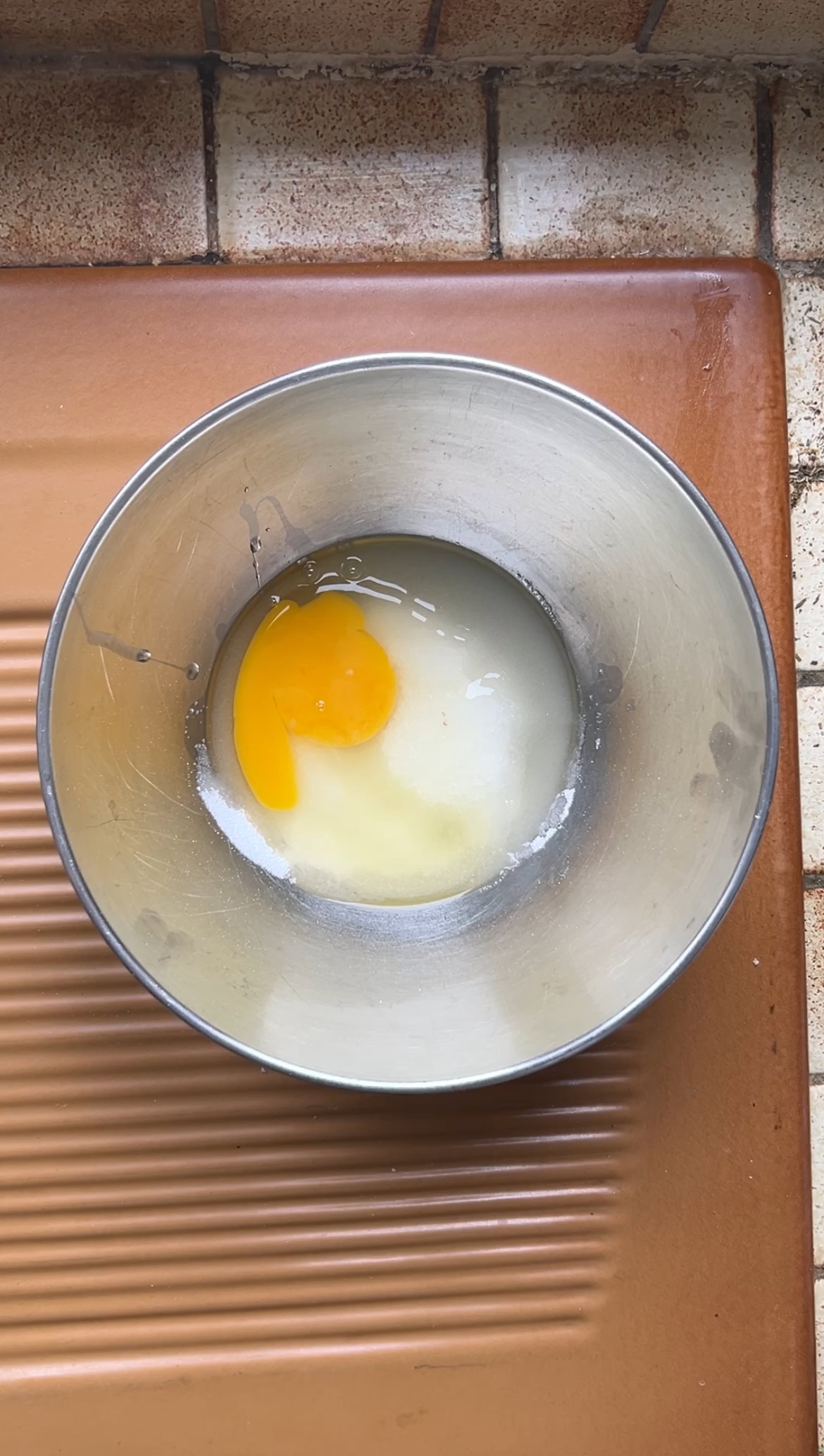 Un oeuf et du sucre dans un bol en inox.