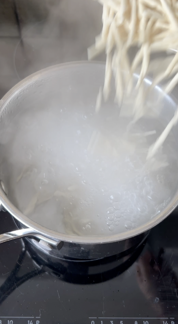 Pâtes qui tombent dans la casserole d'eau bouillante.