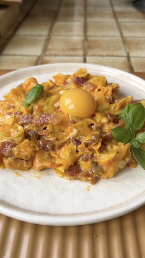 Tagliatelle de courge Carbonara dans une assiette beige.