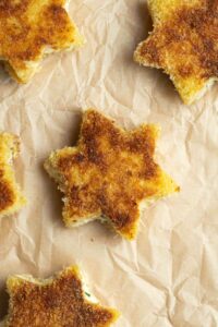 Petits croque-monsieur étoile sur du papier cuisson.